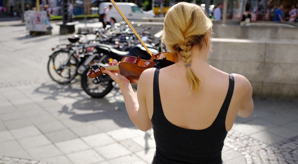 Eine junge Frau spielt Geige auf der Straße