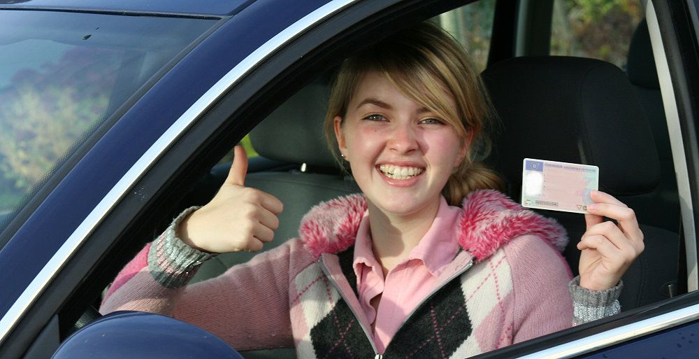 Mädchen hält Führerschein in der Hand